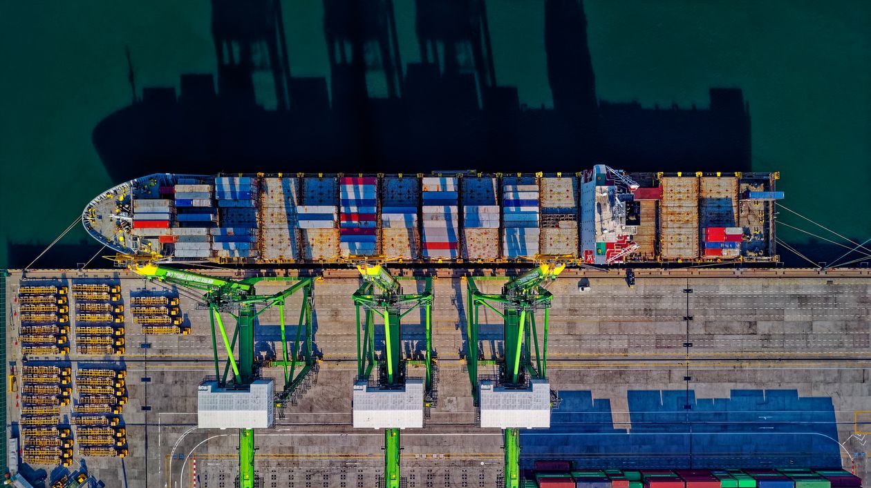 A container vessel alongside port cranes